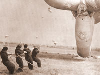Photo: A WAAF team wrestle with one of the huge barrage balloons, raised to keep enemy aircraft at bay